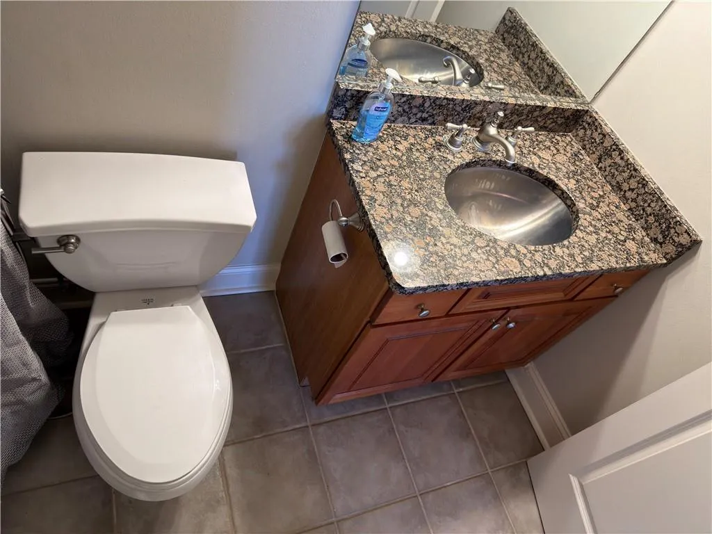 Half bathroom with light tile patterned floors and vanity