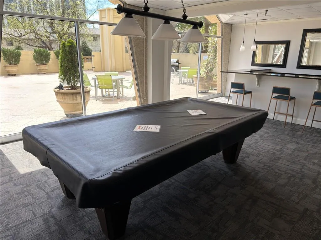 Game room with carpet flooring, floor to ceiling windows, crown molding, and pool table
