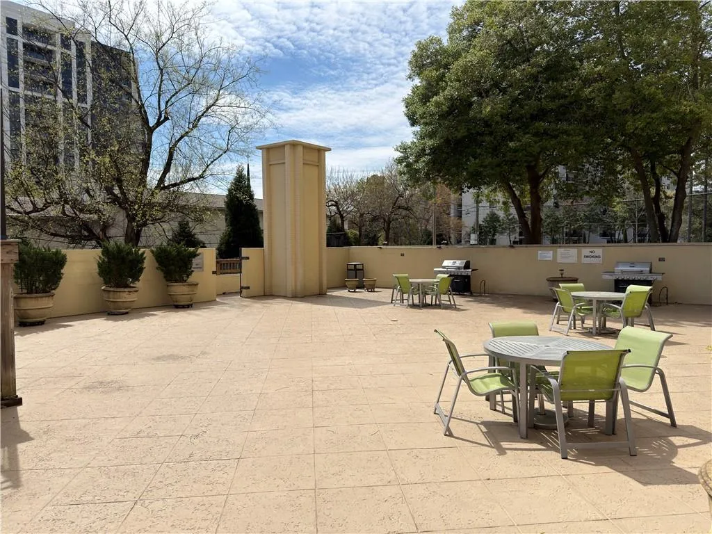 View of patio with outdoor dining space and a grill