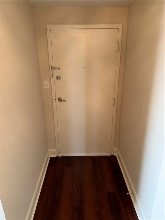 Doorway to outside with wood finished floors and baseboards