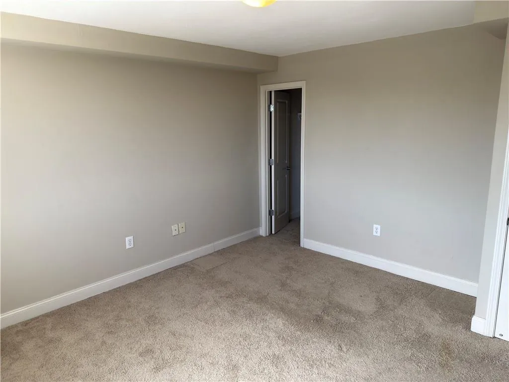 Unfurnished room with baseboards and light carpet