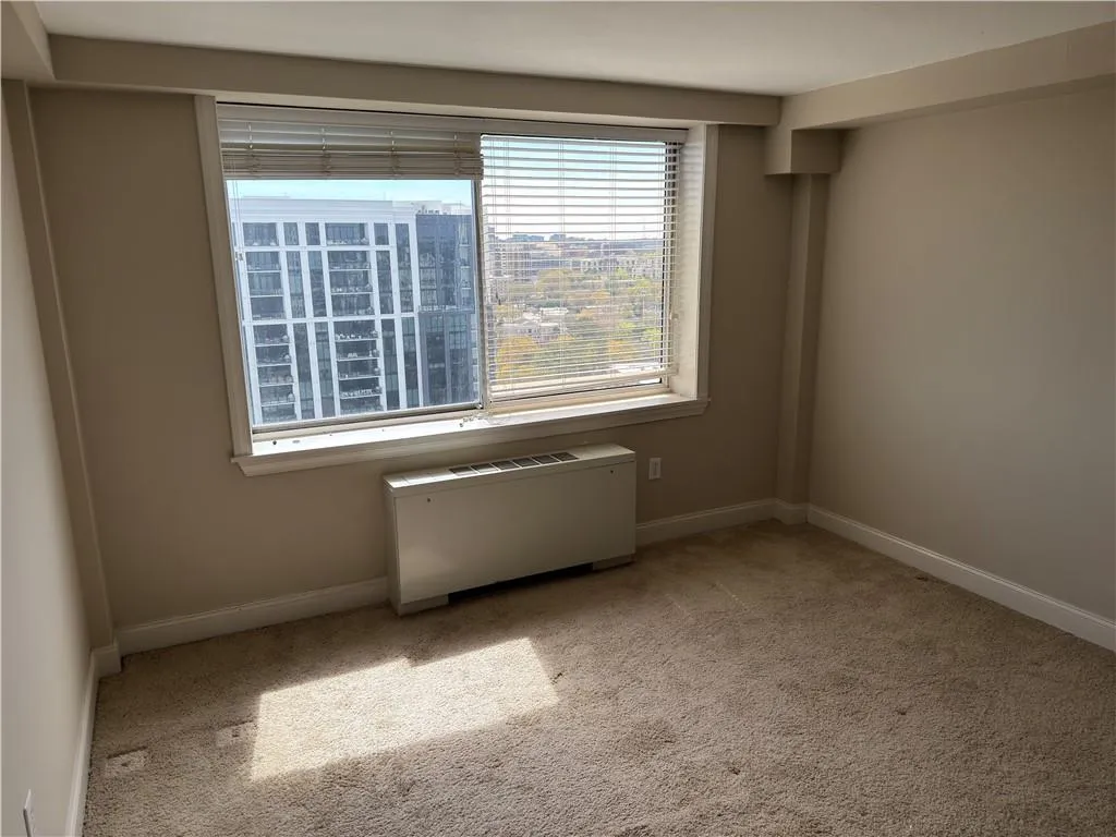 Empty room featuring light carpet and radiator
