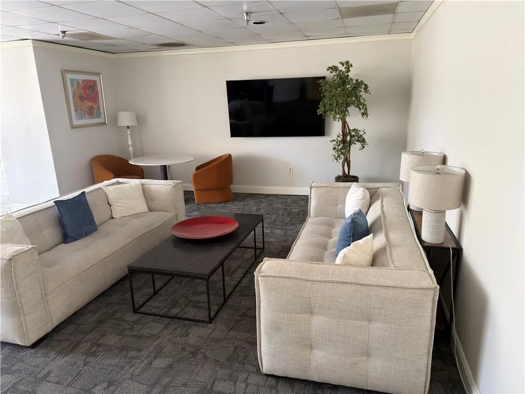 Living area featuring a paneled ceiling and ornamental molding