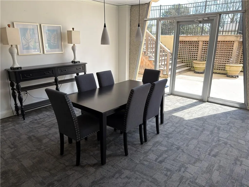 Carpeted dining room with stairs and floor to ceiling windows