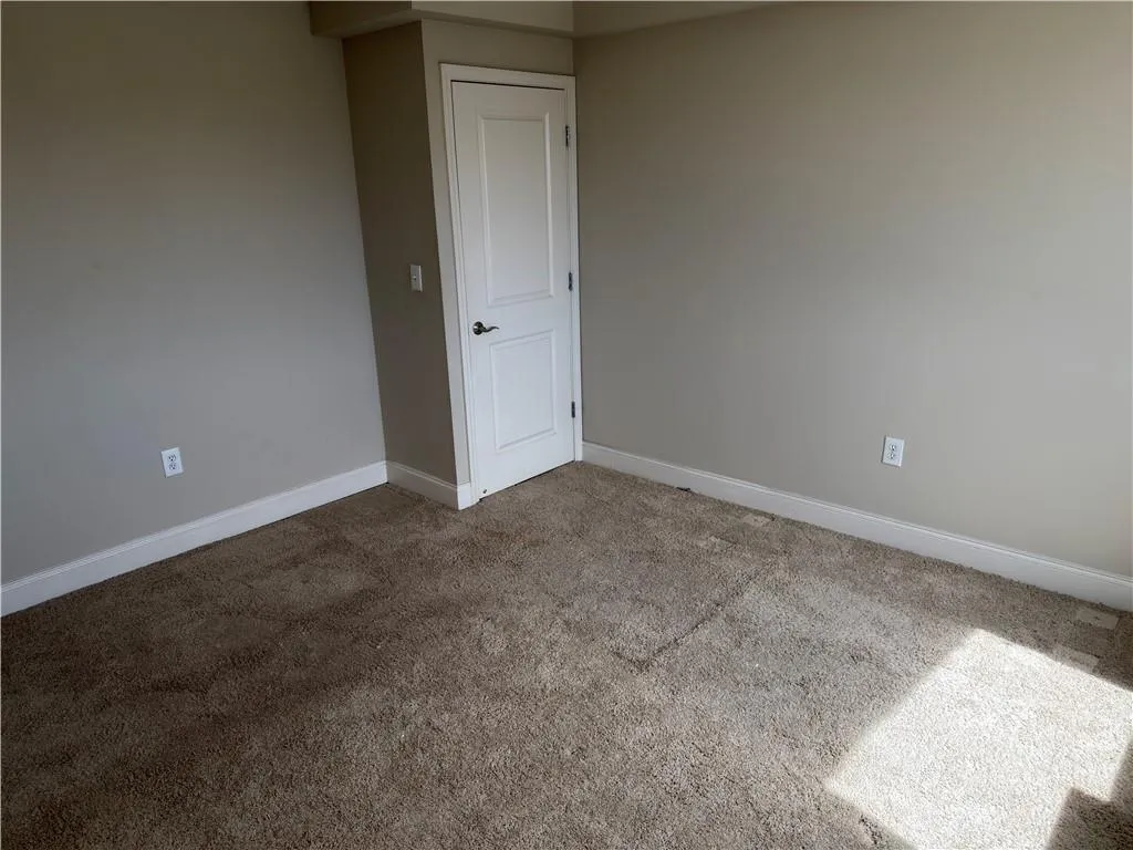 Carpeted spare room with baseboards
