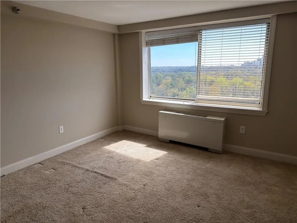 Empty room with light carpet and baseboards
