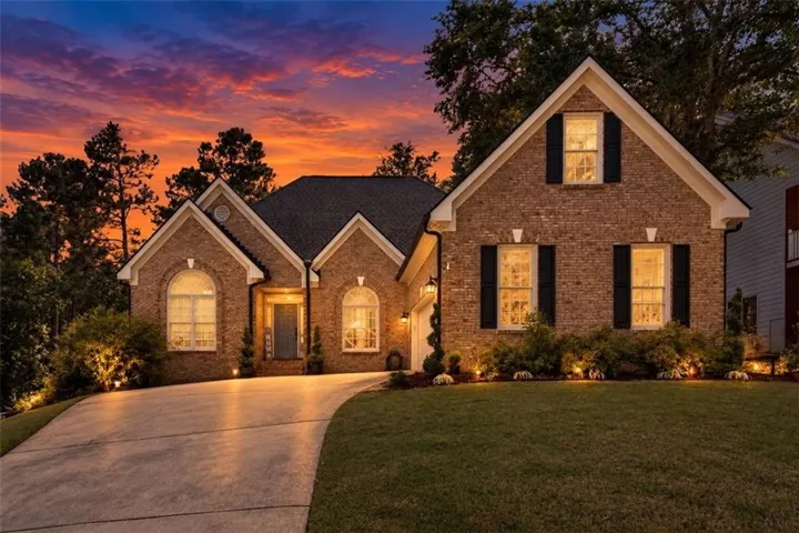 Brick exterior with multiple gables, arched windows, and black shutters