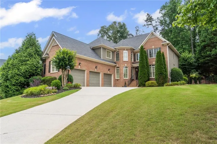 Brick and siding exterior featuring a multi-gable roofline, a three-car garage, and a concrete driveway