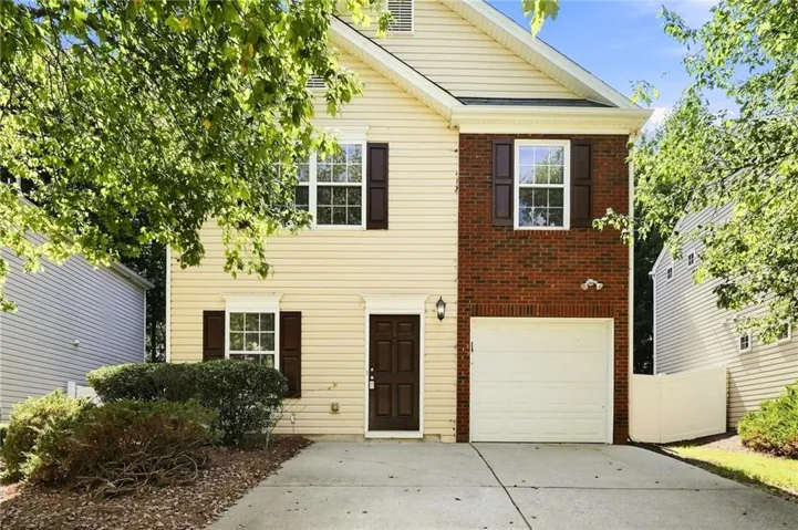 Two-story exterior with light-colored siding and brick accents