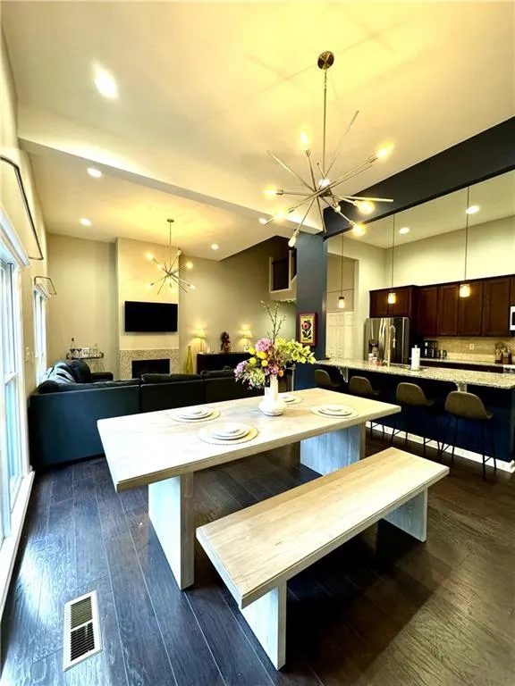 Dining area featuring plenty of natural light, dark hardwood / wood-style floors, and an inviting chandelier