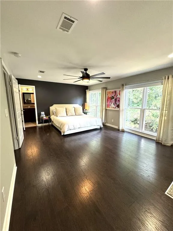 Unfurnished bedroom featuring ceiling fan and dark hardwood / wood-style floors