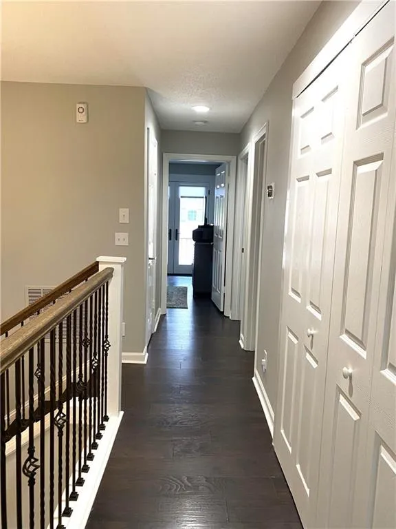 Hall with dark hardwood / wood-style flooring