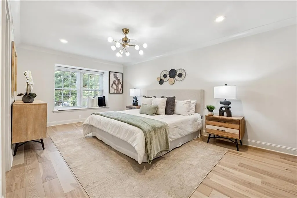 Bedroom featuring light wood-style flooring, ornamental molding, a chandelier, and recessed lighting