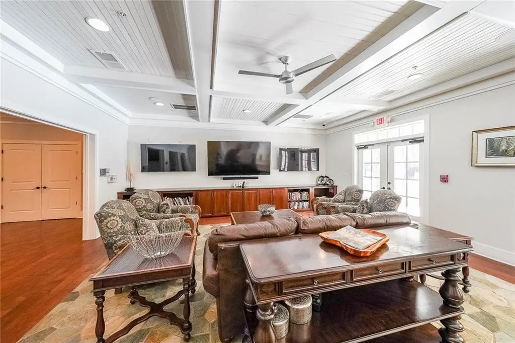 Living room featuring a ceiling fan, wood finished floors, french doors, coffered ceiling, and beam ceiling