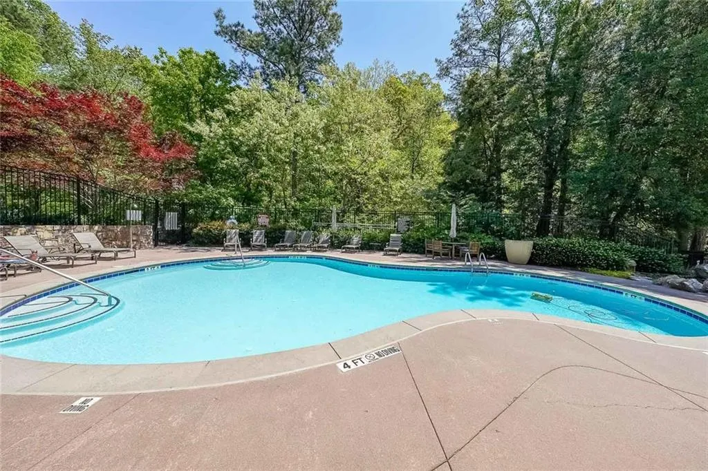 Community pool featuring a patio area and fence