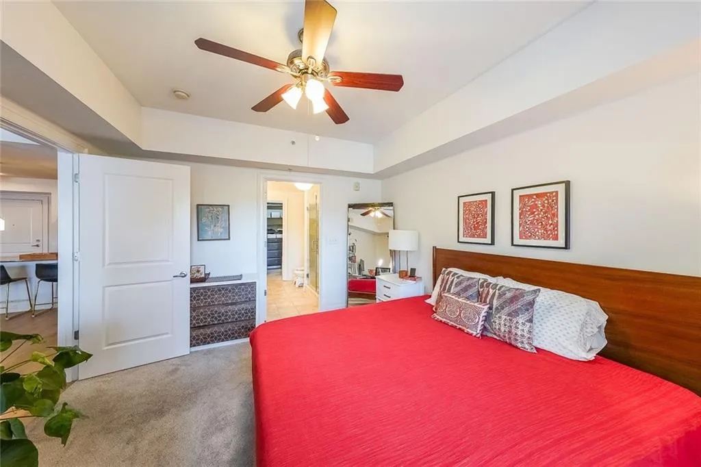 Bedroom with light carpet and a ceiling fan