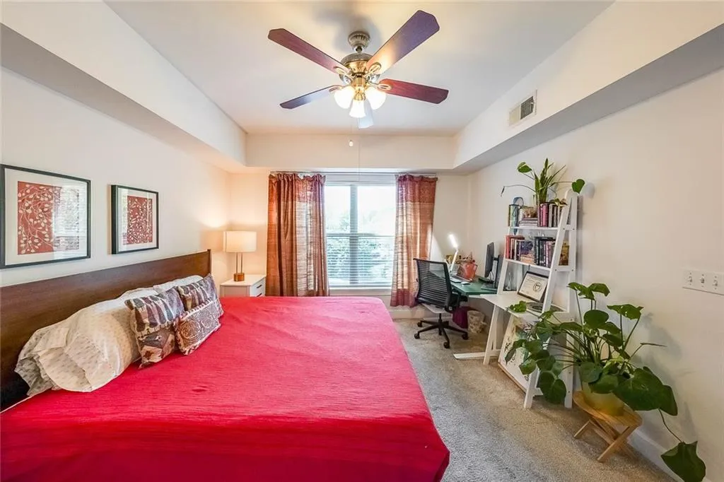Bedroom featuring visible vents, carpet floors, and ceiling fan
