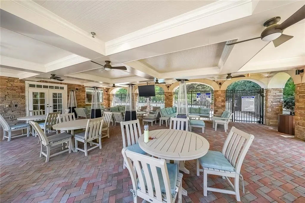 View of patio / terrace featuring fence, outdoor dining space, ceiling fan, and french doors
