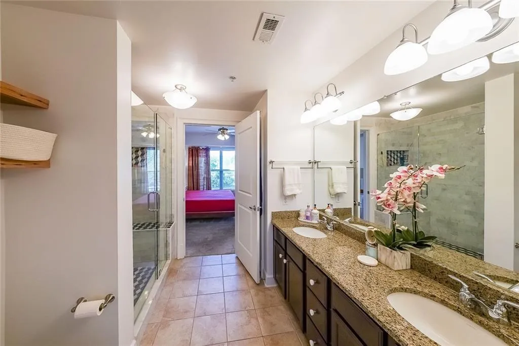 Full bath featuring a sink, visible vents, a ceiling fan, tile patterned flooring, and a shower stall
