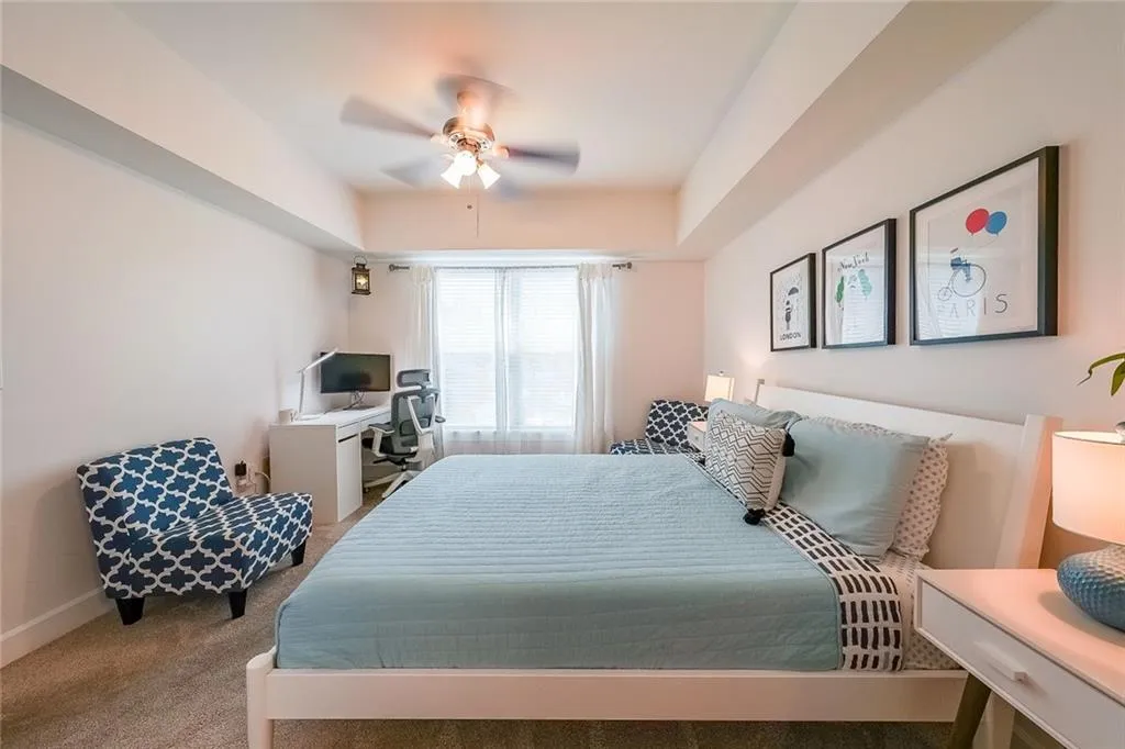 Carpeted bedroom featuring ceiling fan