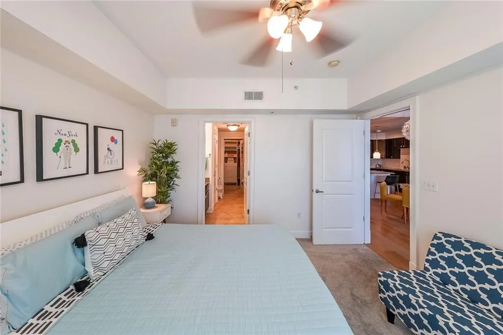 Bedroom with a ceiling fan, visible vents, and light colored carpet