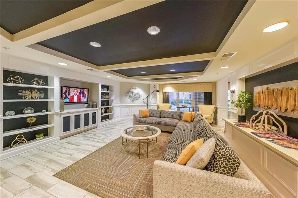 Living area with visible vents, built in features, recessed lighting, and a decorative wall