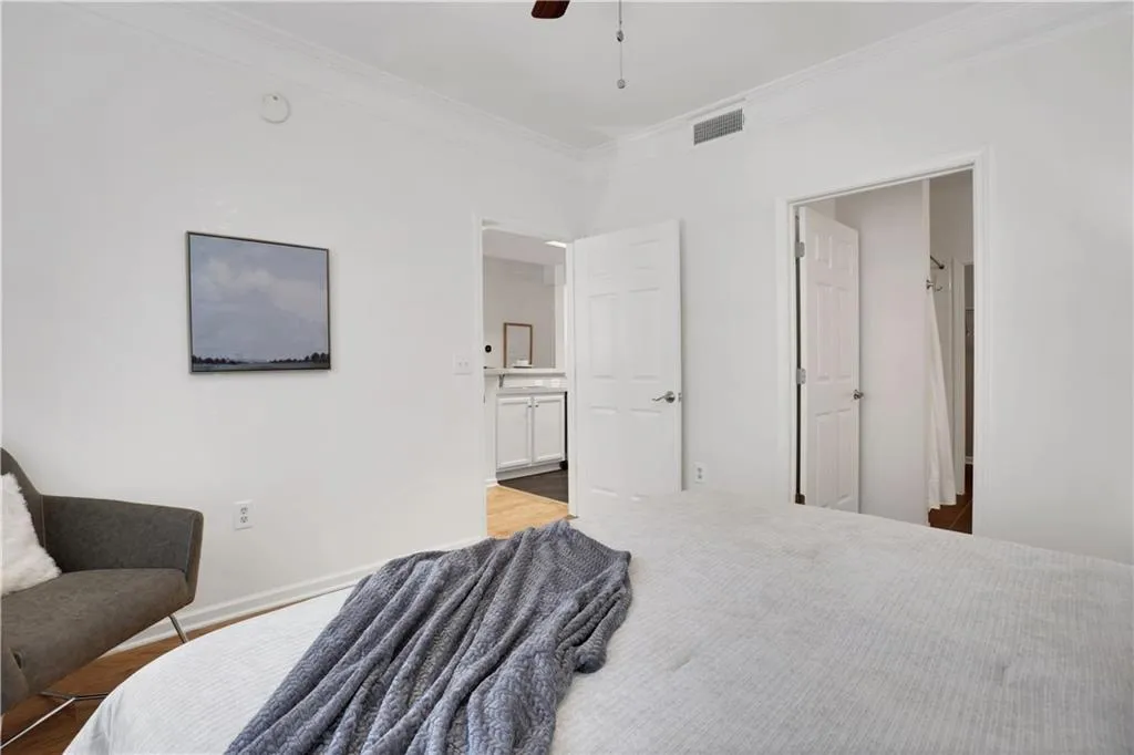 Bedroom with crown molding, ceiling fan, and ensuite bath