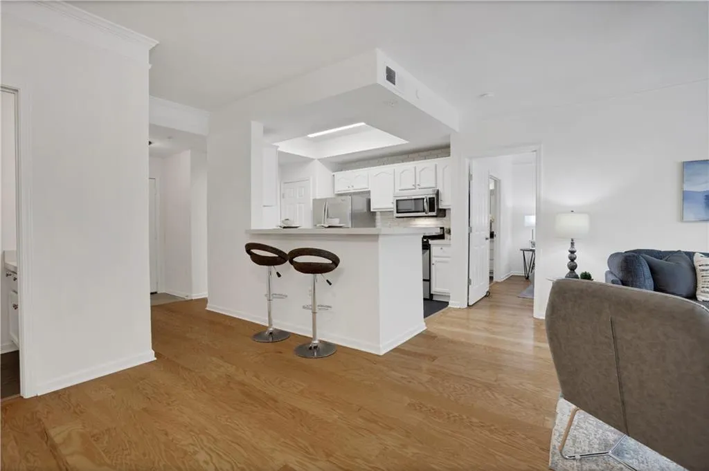 Kitchen featuring white cabinets, a kitchen breakfast bar, a peninsula, open floor plan, and light countertops
