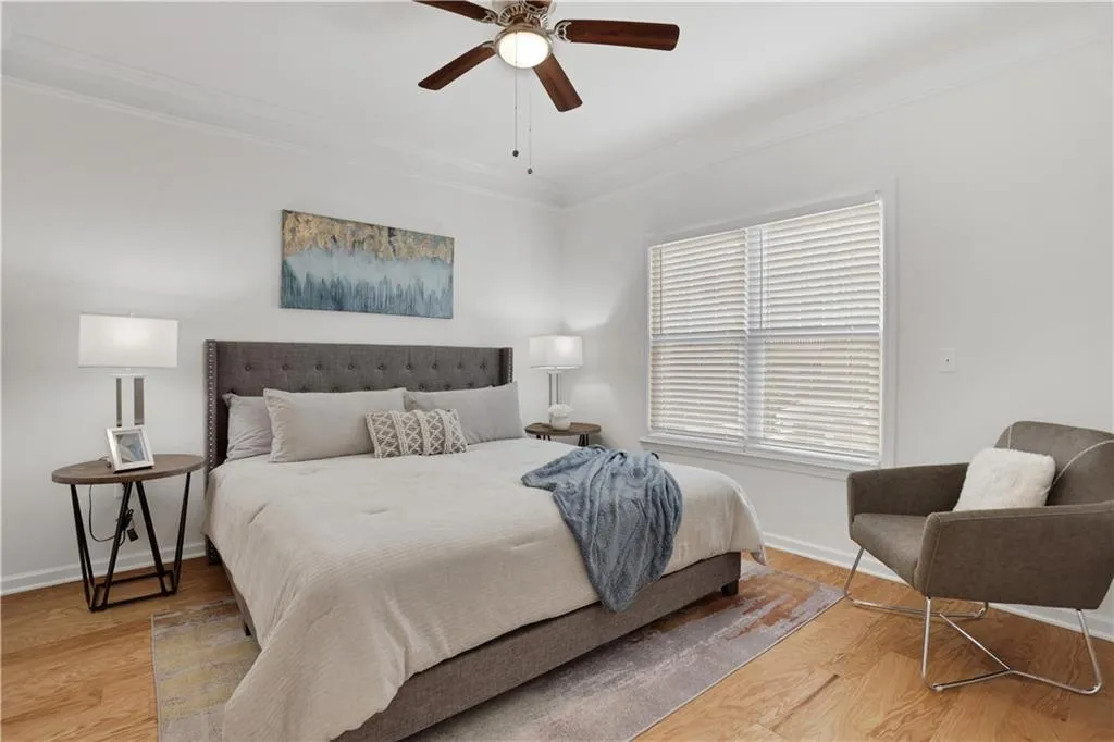 Bedroom featuring crown molding, light wood finished floors, and a ceiling fan