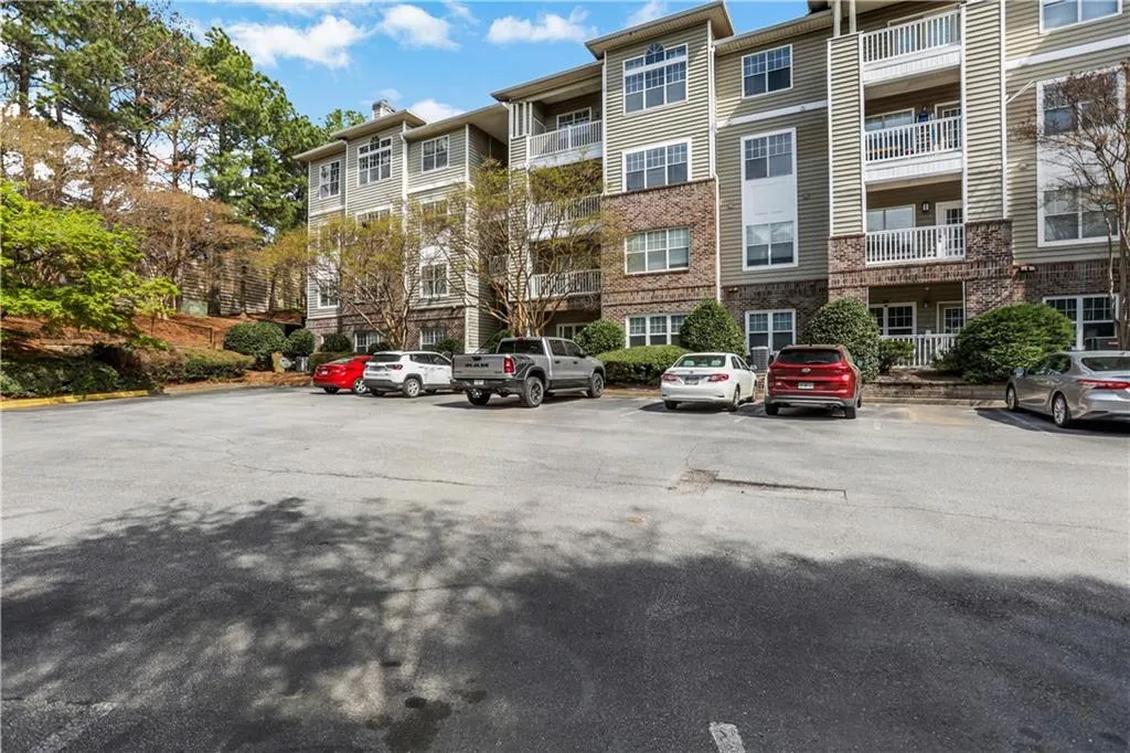View of apartment building / complex with uncovered parking