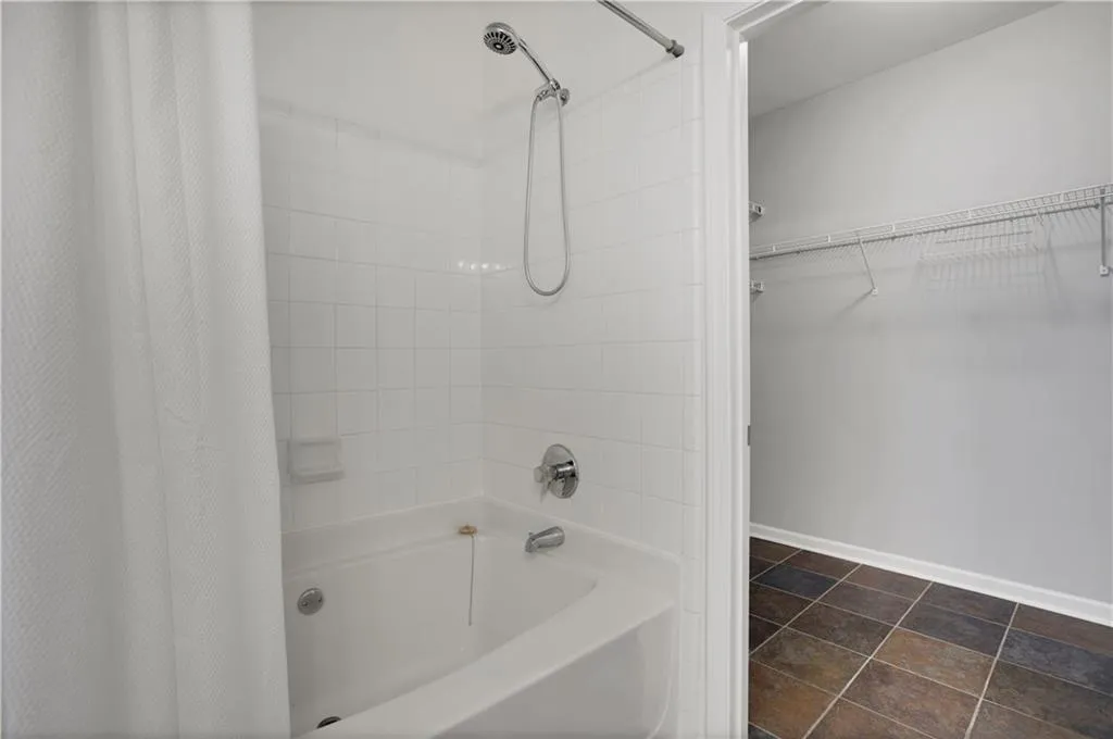 Full bathroom featuring a walk in closet and shower / bathtub combination with curtain