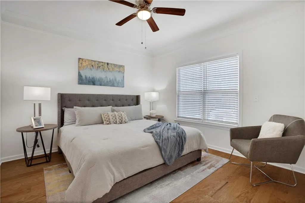 Bedroom featuring ornamental molding, a ceiling fan, and wood finished floors