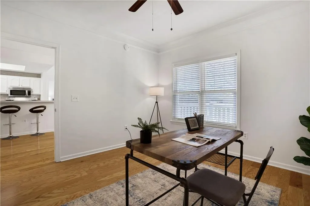 Office area featuring light wood finished floors, a ceiling fan, and ornamental molding