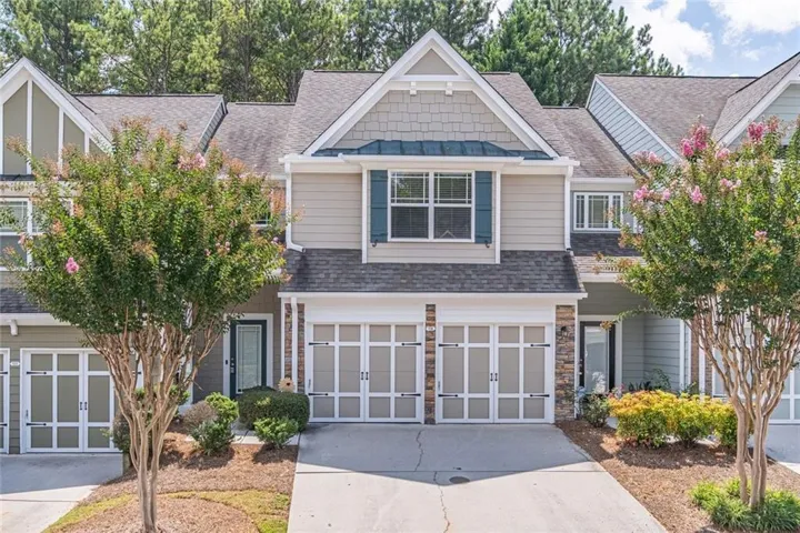 Two-story townhome with neutral siding and stone accents