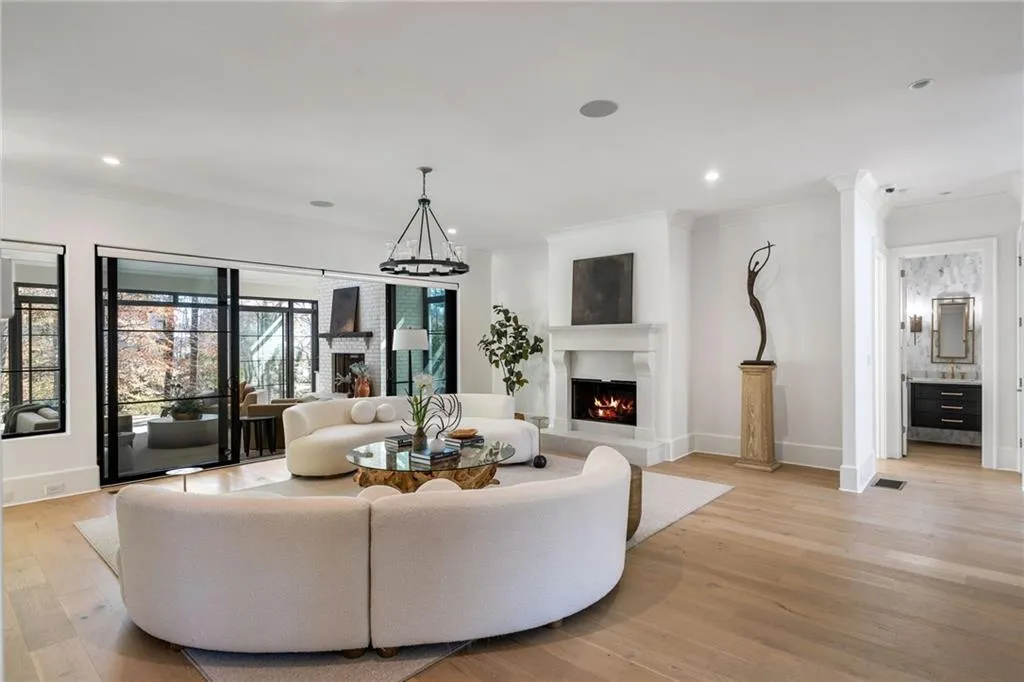Living area featuring crown molding, recessed lighting, light wood-type flooring, a lit fireplace, and baseboards