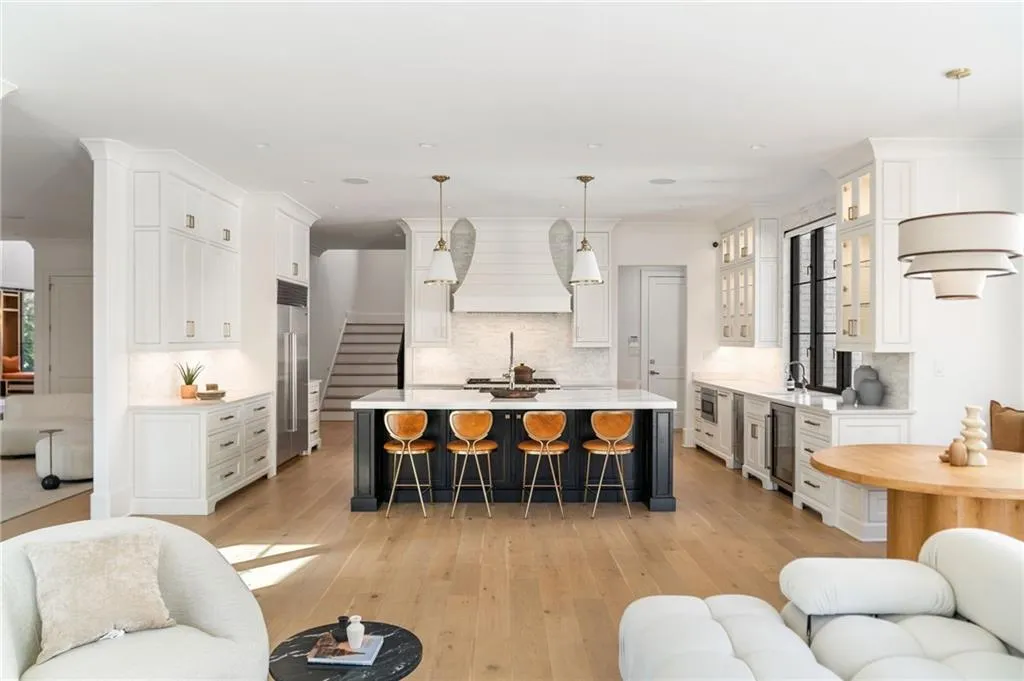 Kitchen with light countertops, open floor plan, a kitchen breakfast bar, premium range hood, and built in refrigerator