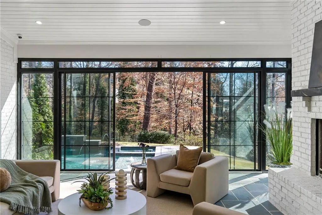 Doorway to outside with a brick fireplace, crown molding, and brick wall