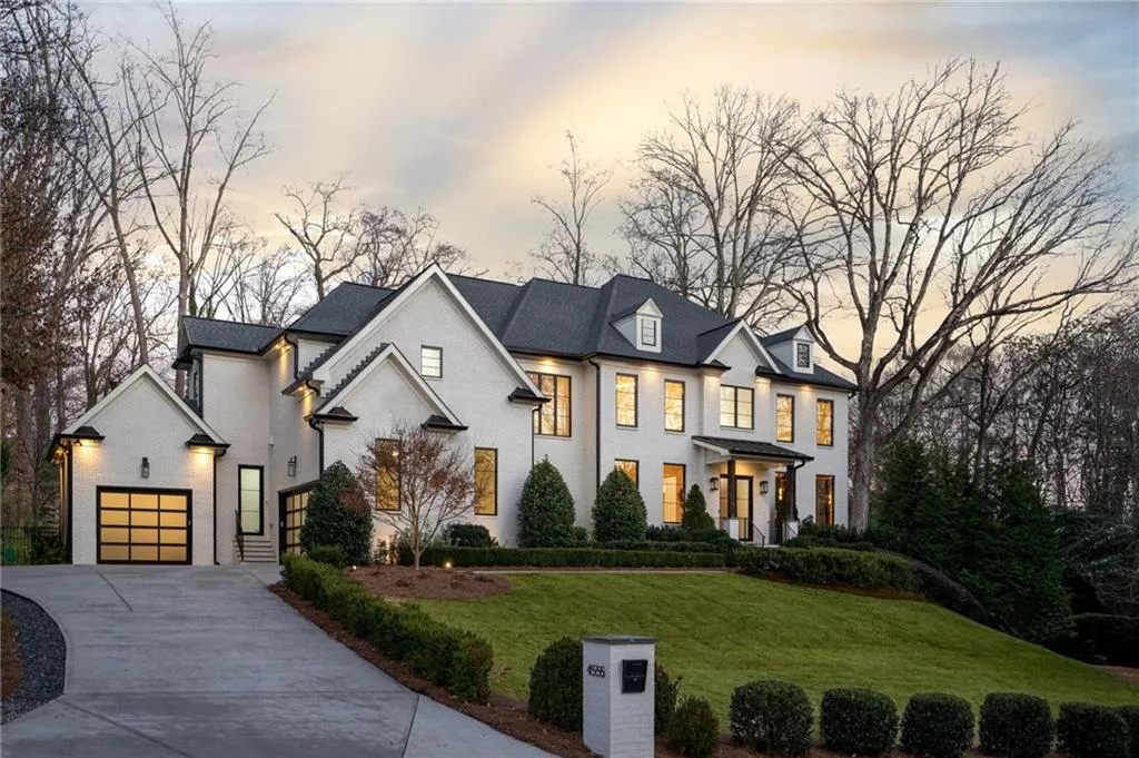 View of front of house featuring concrete driveway, brick siding, a lawn, and an attached garage