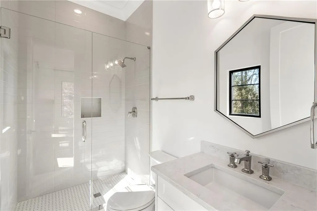 Bathroom featuring toilet, a stall shower, and vanity