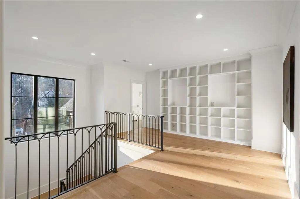 Corridor featuring recessed lighting, ornamental molding, wood finished floors, and an upstairs landing