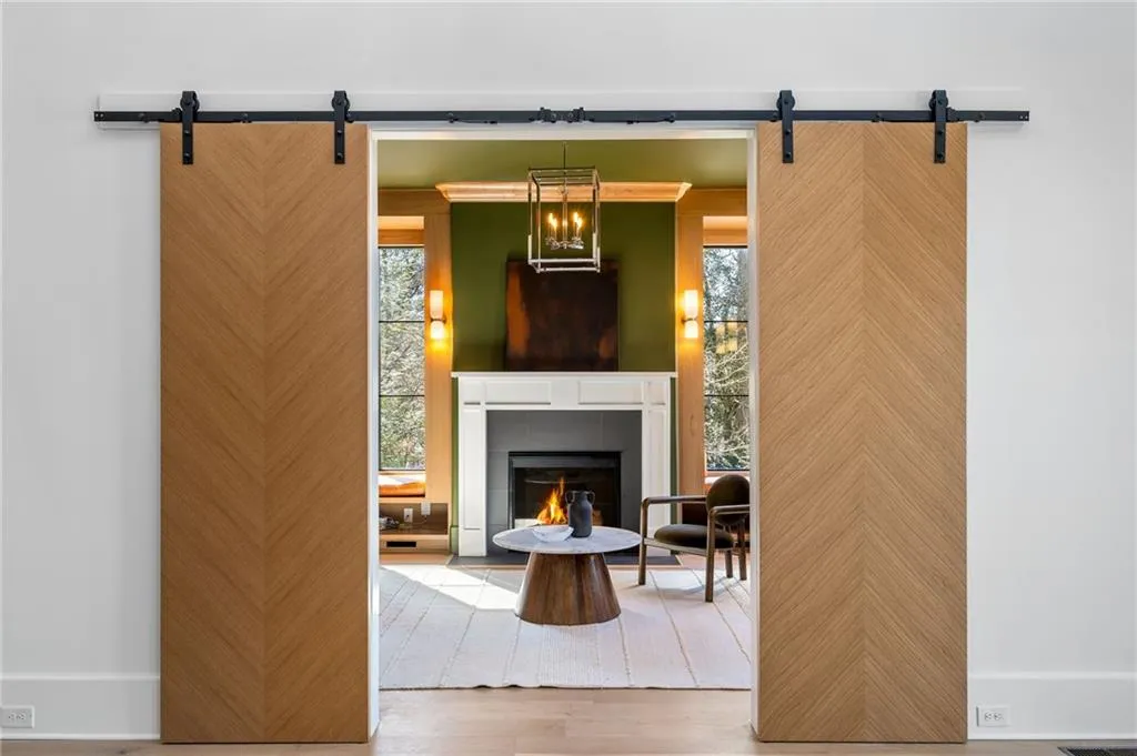 Living area featuring a barn door, a fireplace, and wood finished floors
