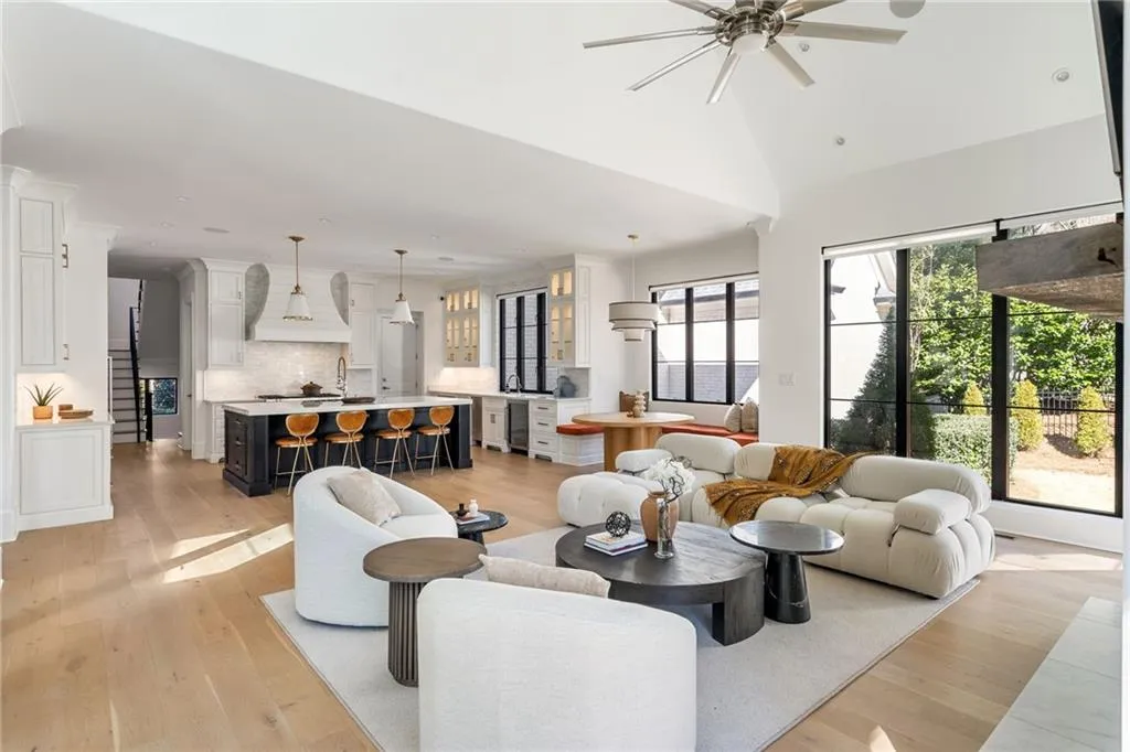 Living room with vaulted ceiling, beverage cooler, light wood-type flooring, and a ceiling fan