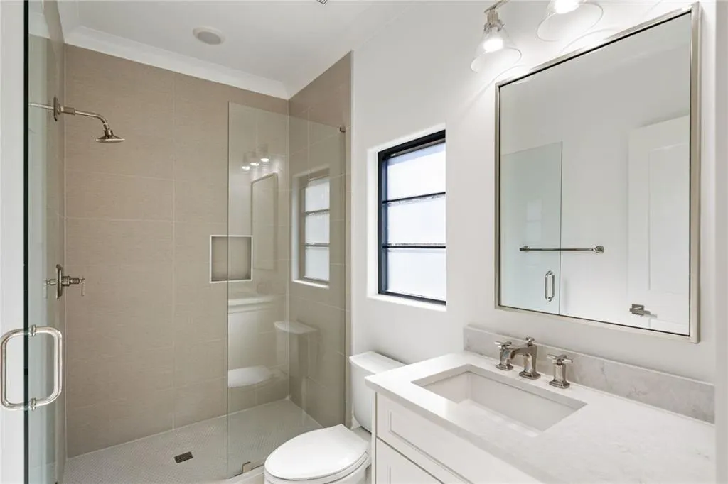 Full bathroom featuring toilet, a stall shower, crown molding, and vanity