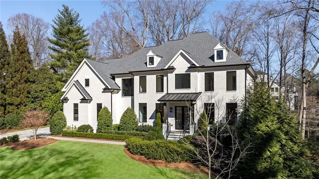 View of front of home featuring roof with shingles, a front lawn, and brick siding