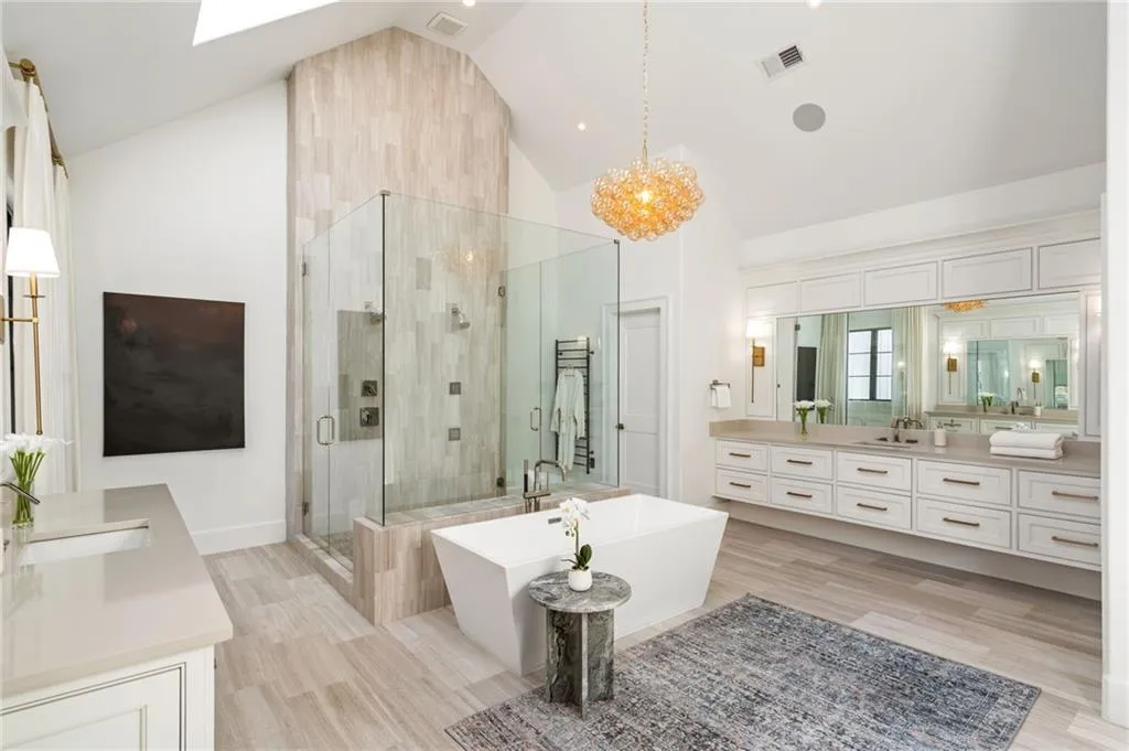 Bathroom with a soaking tub, a shower stall, visible vents, and vanity