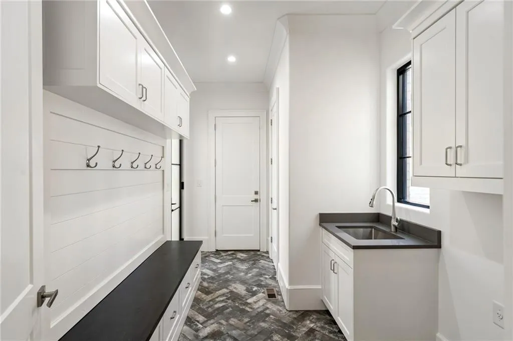 Mudroom with baseboards, brick floor, a sink, and recessed lighting