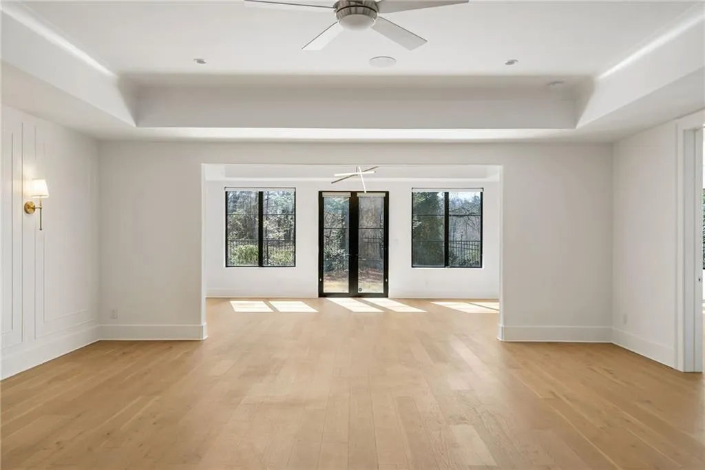 Unfurnished room featuring light wood-style floors, a tray ceiling, and a wealth of natural light