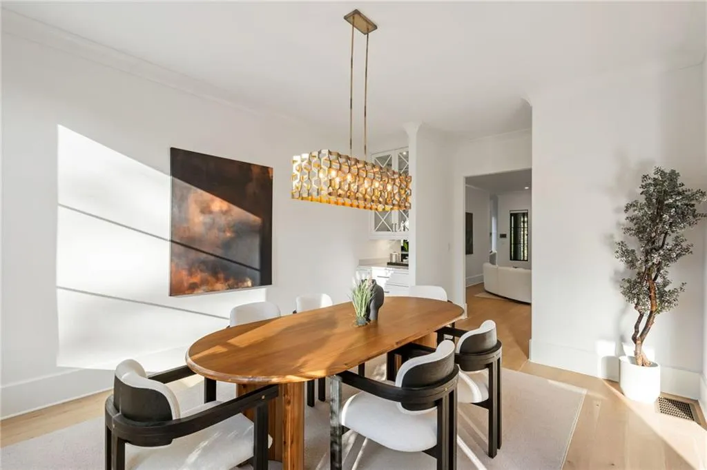 Dining area with ornamental molding, light wood-type flooring, and baseboards