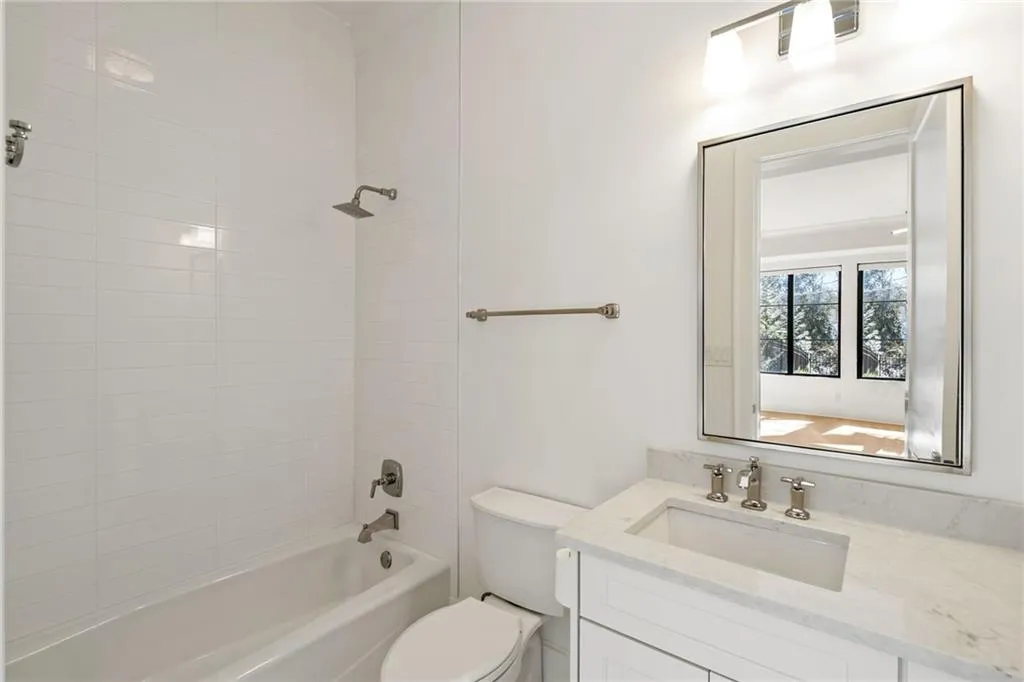 Bathroom with bathtub / shower combination, vanity, and toilet