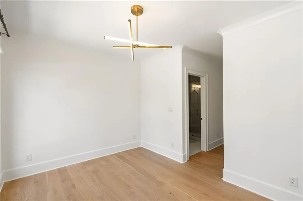 Spare room with light wood-style floors, baseboards, and crown molding